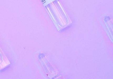 layout of ampoules of covid vaccine on purple surface