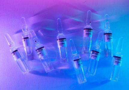 ampoules with antivirus vaccines arranged on desk in laboratory