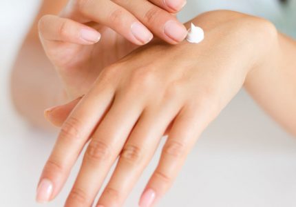woman applying lotion on hand