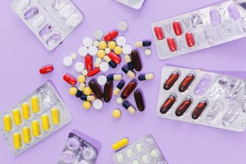 assorted tablets and capsules on purple surface